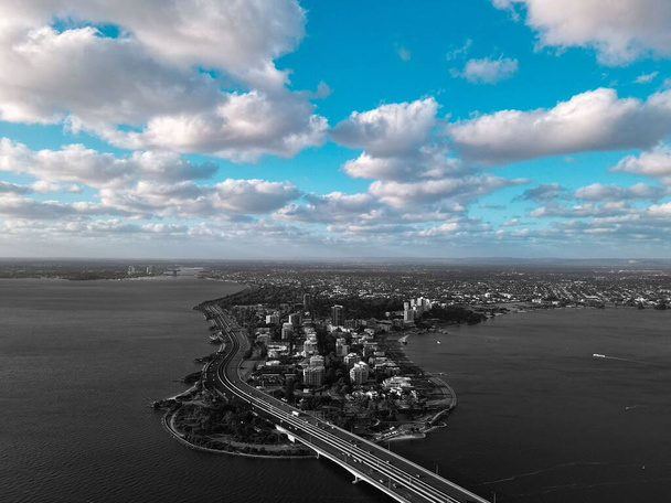 A drone shot of a scenic view of a city under a cloudy blue sky in Australia - Foto, immagini