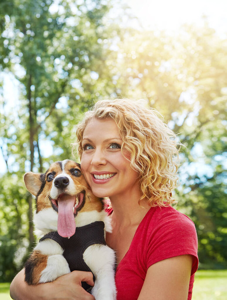 Виховання собаки вносить багато любові в повсякденне життя. молода жінка зв'язується зі своєю собакою в парку
 - Фото, зображення