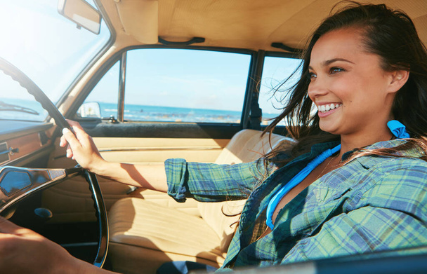 She loves being on the road. a young woman on a road trip near the ocean - Photo, Image