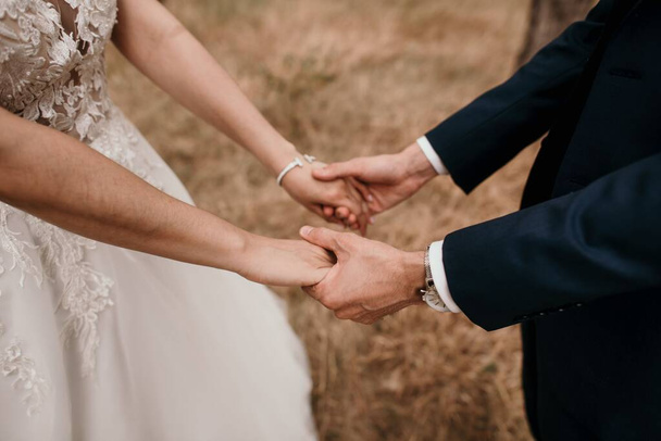 A couple holding each others' hands during the wedding ceremony - Fotoğraf, Görsel