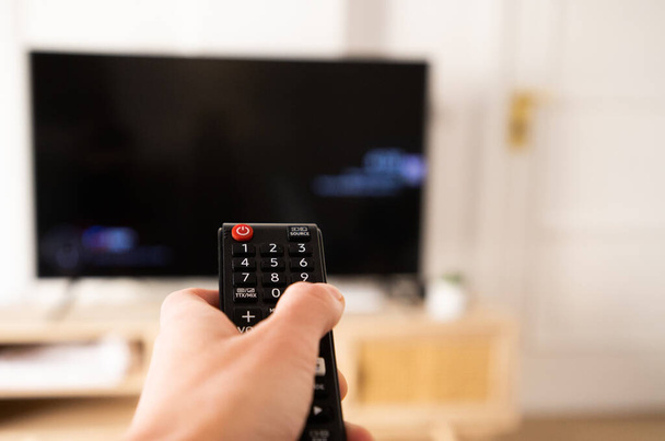hand with remote control for tv set - Φωτογραφία, εικόνα