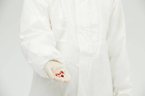 A doctor in uniform and gloves holding drugs - Fotoğraf, Görsel