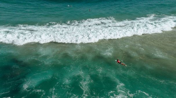 A surfer facing huge waves at the beach in Rio de Janeiro, Brazil - Fotografie, Obrázek
