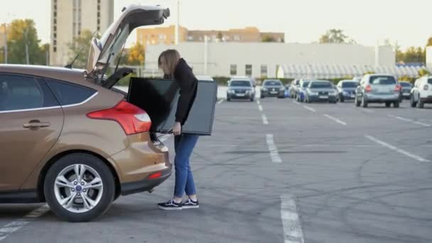 Nainen vetää ulos moderni tv auton runko supermarket pysäköinti lähikuva, toimitus käsite - Materiaali, video