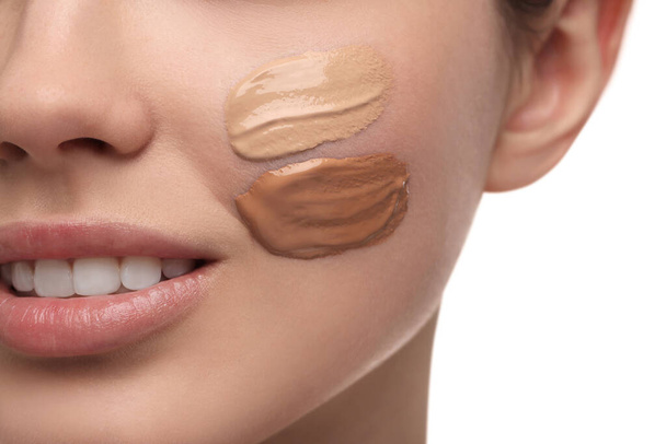 Teenage girl with swatches of foundation on face against white background, closeup - Foto, Imagem