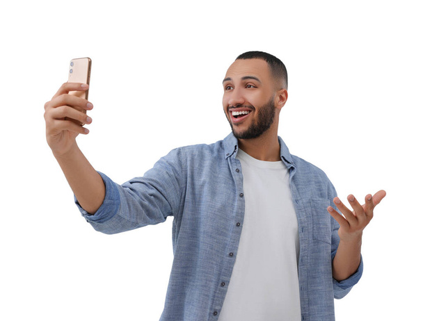 Smiling young man taking selfie with smartphone on white background - Fotoğraf, Görsel