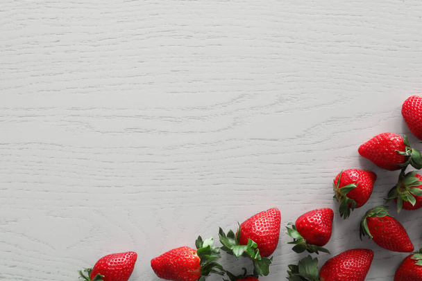 Food photography. Delicious ripe strawberries on white wooden table, flat lay with space for text - Foto, afbeelding