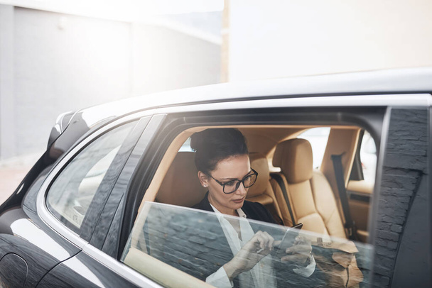 Робочі дні для зайнятих людей. впевнена молода бізнес-леді сидить в машині як пасажир під час смс на її телефоні на її шляху до роботи
 - Фото, зображення