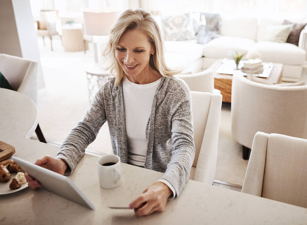 Linhas de compras Não obrigado. uma mulher madura usando um cartão de crédito e tablet digital enquanto relaxa em casa - Foto, Imagem