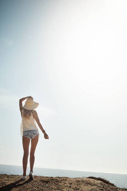La stagione del divertimento al sole. Retrovisore di una giovane donna attraente che si gode la sua giornata sulla spiaggia - Foto, immagini