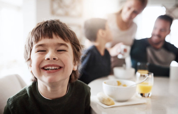 The biggest smiles begin with breakfast. Portrait of a happy little boy enjoying breakfast together with his family at home - 写真・画像