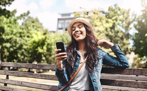 У парку зі своїми соціальними медіа. приваблива молода жінка використовує мобільний телефон у парку
 - Фото, зображення