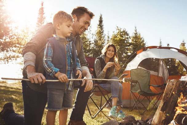 スモアとは、特にキャンプ時に意味します。森の中でキャンプしている若い家族が - 写真・画像