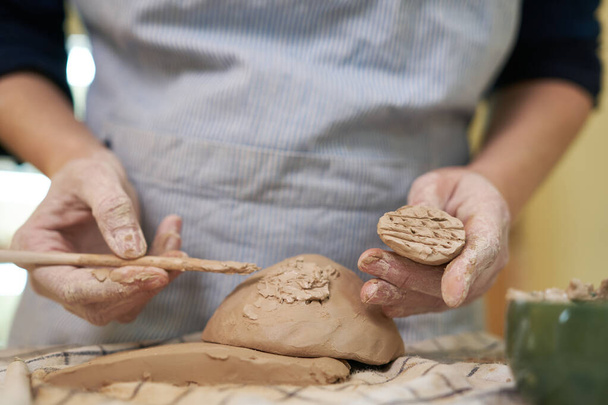 woman forming clay pot shape by hands, closeup in artistic studio. - Foto, Bild