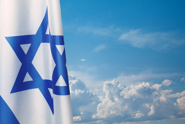 Σημαία Ισραήλ με αστέρι του Δαβίδ πάνω από θολό φόντο του ουρανού. Πατριωτική αντίληψη για το Ισραήλ με εθνικά κρατικά σύμβολα. Banner με θέση για κείμενο. - Φωτογραφία, εικόνα