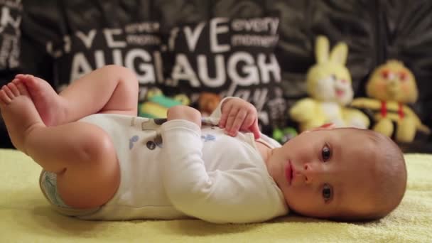 Imádnivaló baba kisfiú feküdt, és mosolyogva - Felvétel, videó
