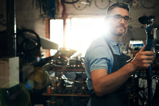 Оставь это велосипедному профессионалу. Портрет взрослого человека, работающего в мастерской по ремонту велосипедов - Фото, изображение