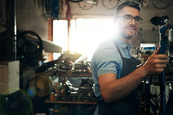 しっかりとした修復で自転車に命を吹き込みます。自転車修理屋で働く大人の男性の肖像画 - 写真・画像
