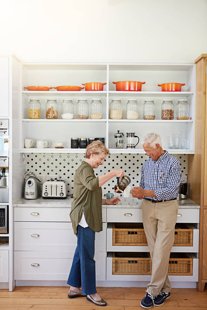 Heiraten Sie eine Frau, die großartigen Kaffee macht. Ein glückliches Seniorenpaar beim Kaffee in der heimischen Küche - Foto, Bild