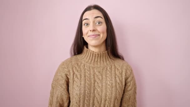 Fiatal gyönyörű spanyol nő mosolygós magabiztos mond igen fej felett elszigetelt rózsaszín háttér - Felvétel, videó