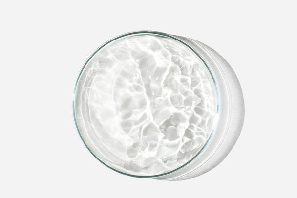 Piastra di Petri su fondo chiaro con liquido, acqua. Schizzi d'acqua. Le onde nella capsula di Petri. Vista dall'alto. Laboratorio - Foto, immagini