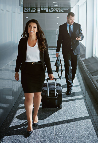 Pack your best suit, its time for a business trip. two executive businesspeople walking through an airport during a business trip - Fotoğraf, Görsel
