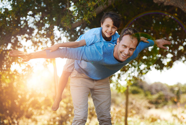 Aerolíneas de papá volador. Retrato de un padre y su hijo pequeño pasando tiempo de calidad juntos fuera - Foto, imagen