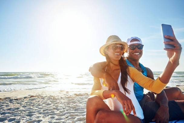 Formaggio ai ricordi che vale la pena catturare. una giovane coppia felice che si fa un selfie sulla spiaggia - Foto, immagini