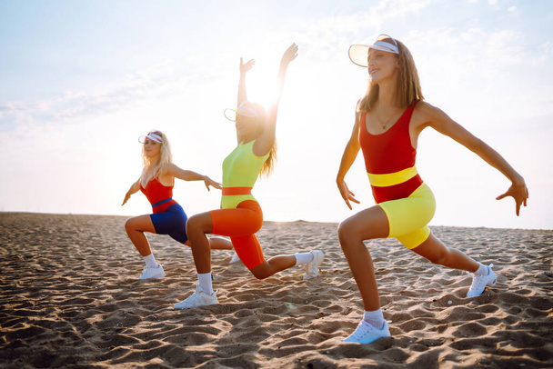 Young dancers in colorful swimsuits are dancing in the morning. oncept of sports, fitness, aerobics. Active sport. - Photo, Image