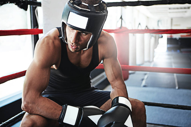 Er hat den Fokus der Kämpfer. ein junger Mann beim Training im Boxring - Foto, Bild