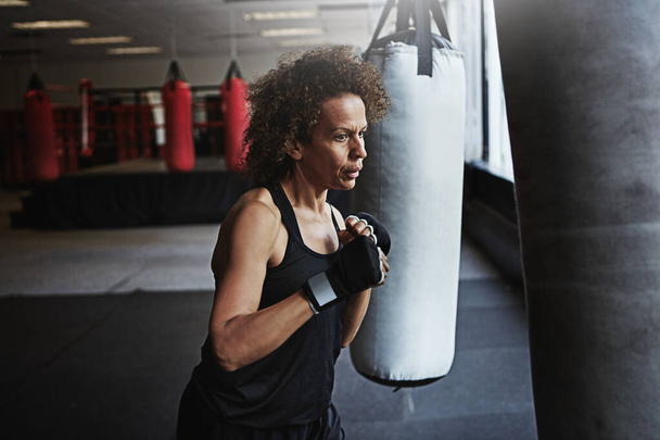 Necesitaba un héroe así que se convirtió en uno. un entrenamiento femenino de kick-boxer en el gimnasio - Foto, imagen