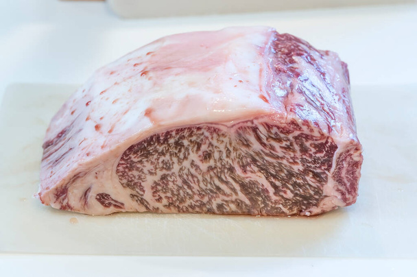 Japanese Wagyu beef with marbled fat, a delicacy in Japan. Wagyu beef has an increased fat percentage due to a decrease in grazing and an increase in using feed, resulting in larger, fattier cattle. - Foto, Bild