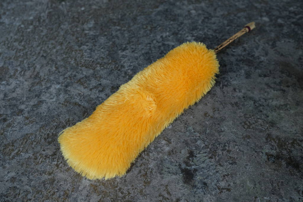 yellow duster on black floor - Photo, Image