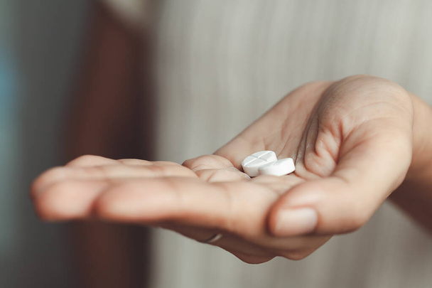 Dos píldoras blancas en la mano de la mujer asiática para el concepto médico y de salud. - Foto, Imagen