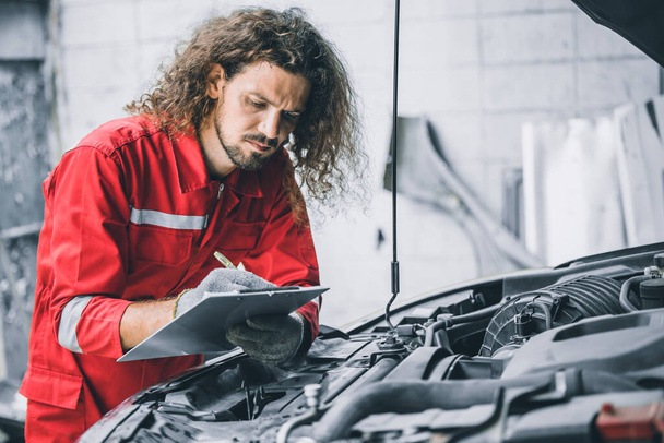 Mechanik mužský tým pracovník pracující s automobilovým problémem motor auto servis kontrola nahradit seznam dílů v garáži - Fotografie, Obrázek