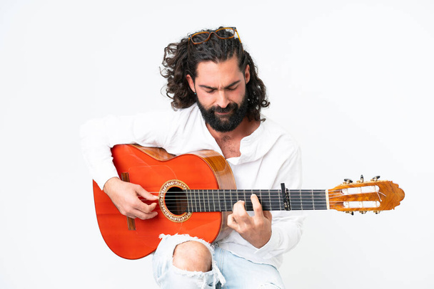 Young man with beard playing guitar on white background - Photo, image