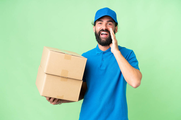 Delivery caucasian man over isolated chroma key background shouting with mouth wide open - Photo, Image