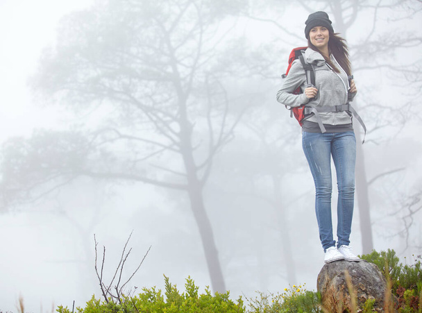 Entrer en contact avec la nature. une belle jeune femme debout sur un rocher en randonnée - Photo, image