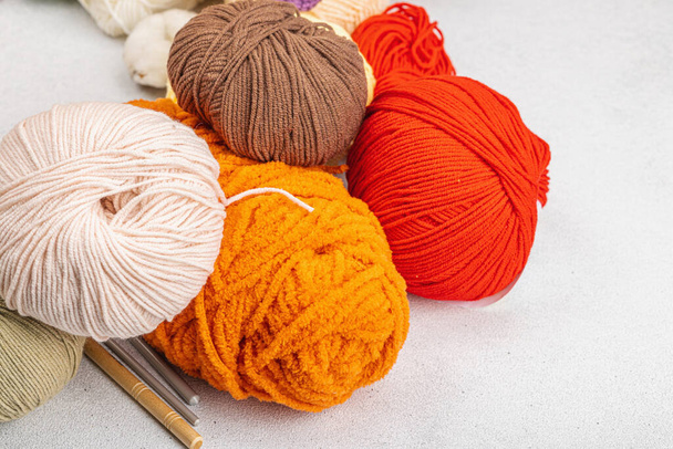 Un ensemble de clou coloré de fil pour le tricot et les outils artisanaux spéciaux. Fait main, passe-temps, concept de crochet. Accessoires et trucs sur fond de béton de pierre claire, gros plan - Photo, image