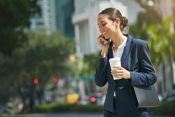 A gerir os seus compromissos de trabalho em movimento. uma jovem empresária conversando em seu telefone enquanto na cidade - Foto, Imagem