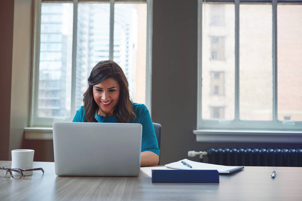 Czytanie miesięcznego biuletynu informacyjnego dla pracowników. bizneswoman korzystająca z laptopa w biurze - Zdjęcie, obraz