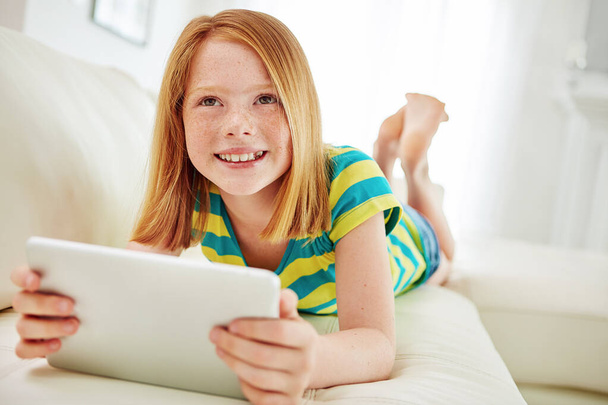 Technology keeps up with her enquiring mind. a little girl using a digital tablet at home - Foto, Bild