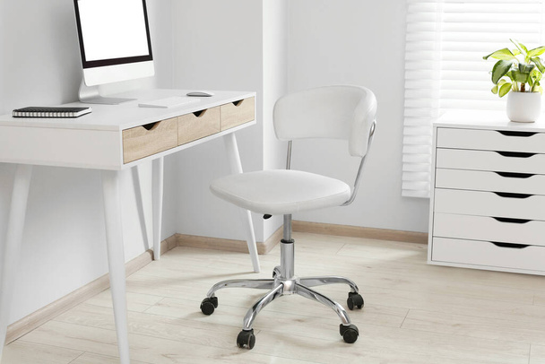 Stylish office interior with comfortable chair, desk and computer - Foto, Bild