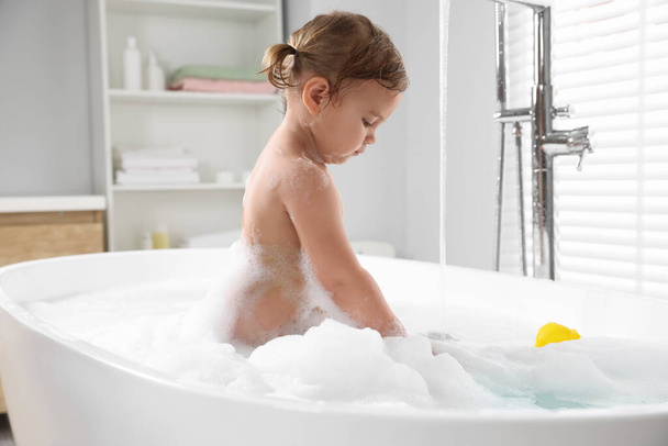 Cute little girl in foamy bath at home - Zdjęcie, obraz