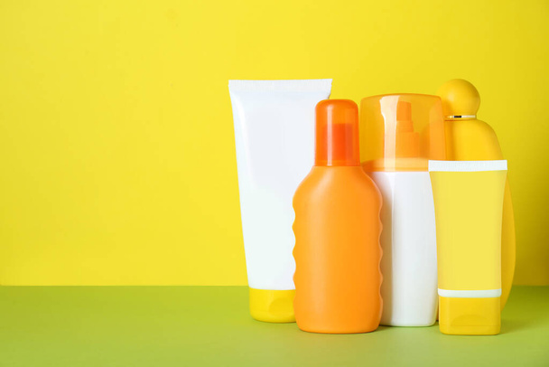 Different suntan products on color background. Space for text - 写真・画像