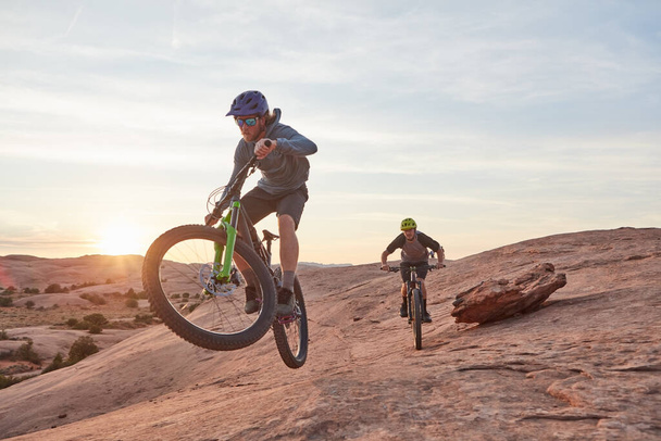 Życie na krawędzi. Pełna długość ujęcia dwóch młodych sportowców kolarstwo górskie na pustyni - Zdjęcie, obraz