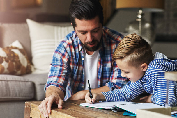 I padri sono sempre qui per aiutare. un padre che aiuta suo figlio con i compiti - Foto, immagini
