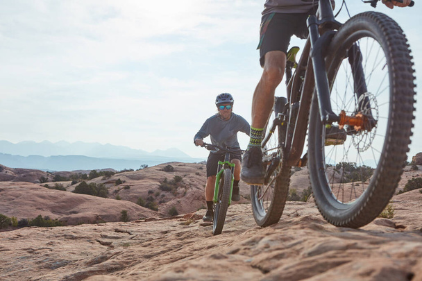 Vivi la tua passione. due uomini atletici in mountain bike attraverso il deserto - Foto, immagini