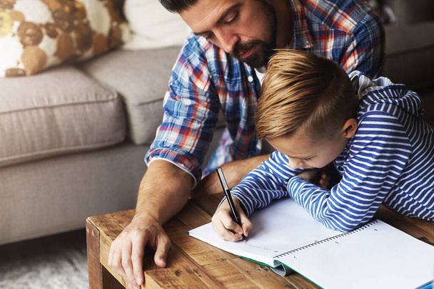 Väter sind zur Stelle, um zu helfen. ein Vater hilft seinem kleinen Sohn bei den Hausaufgaben - Foto, Bild