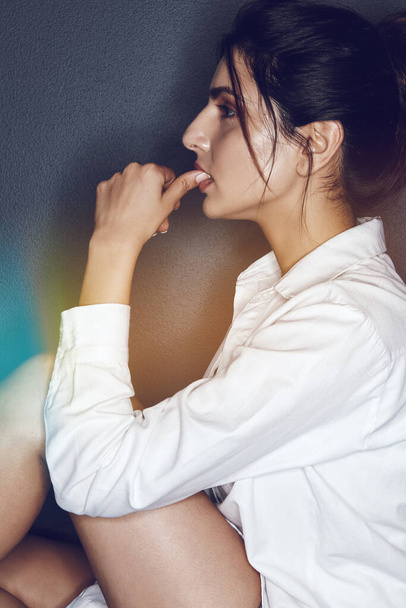 Feeling a little flirty. Studio shot of an attractive young woman posing against a dark background - Fotoğraf, Görsel